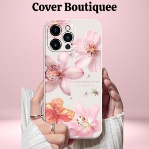 Könnte beinhalten: Eine Handyhülle mit floralem Design mit rosa und orangefarbenen Blumen, Perlen und dem Text "Do everything in love". Die Hülle hat einen weißen Hintergrund und wird von einer Person gehalten. Der Markenname "Cover Boutiquee" steht oben.
