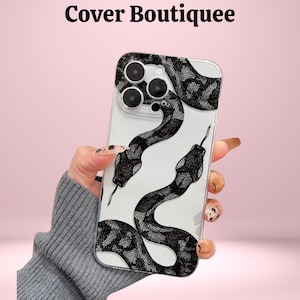 May include: Clear phone case featuring a black and white snake design. The snake pattern is detailed and covers the back of the phone case. The text "Cover Boutiquee" is at the top of the image.