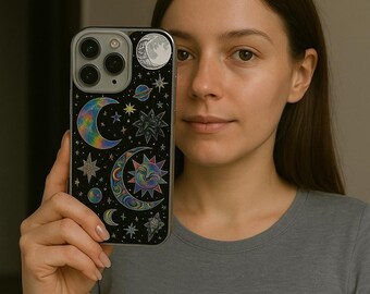 May include: A black smartphone case featuring a celestial design with moons, stars, and planets in vibrant colors. The case has a glossy finish and a camera cutout.
