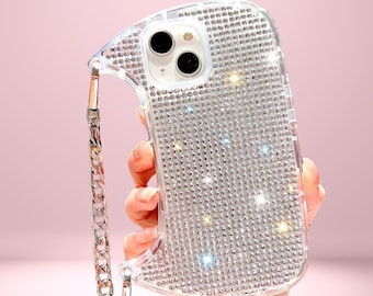 May include: Clear phone case encrusted with sparkling rhinestones, featuring a silver chain strap. The case has a dual-camera cutout and the text "Cover Boutiquee" at the top.