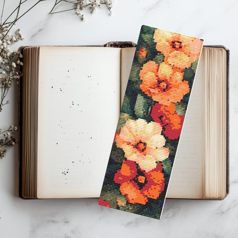 May include: A floral bookmark with a design of orange and white flowers on a dark green background.