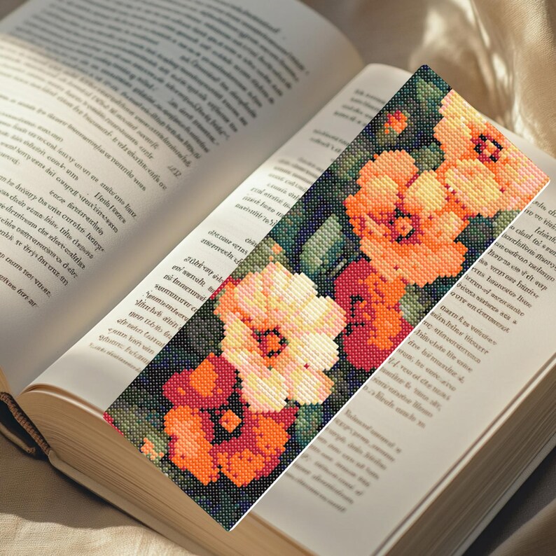 May include: A bookmark with a floral design featuring orange, white, and red flowers on a dark green background.