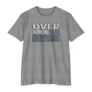 May include: A gray t-shirt with the text "OVER THINKING SOLVES EVERYTHING" in a layered design. The top layer of the text is white, the middle layer is gray, and the bottom layer is blue.