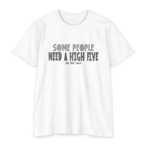 May include: White t-shirt with the text "SOME PEOPLE NEED A HIGH FIVE IN THE FACE" in gray letters. The shirt has short sleeves and a crew neck. The text is centered on the front of the shirt.