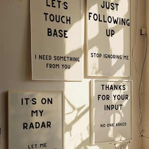 Puede incluir: Cuatro impresiones enmarcadas con texto humorístico en una pared blanca. Las impresiones presentan el siguiente texto: "Let's touch base I need something from you", "Just following up Stop ignoring me", "It's on my radar Let me procrastinate", y "Thanks for your input No one asked".