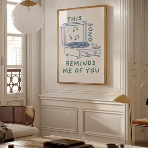 A minimalist illustration of a vintage record player with the text This song reminds me of you, placed on a neutral beige background. The design features a clean, hand-drawn aesthetic with simple, modern lines.