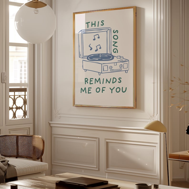 A minimalist illustration of a vintage record player with the text This song reminds me of you, placed on a neutral beige background. The design features a clean, hand-drawn aesthetic with simple, modern lines.