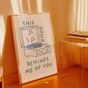 A minimalist illustration of a vintage record player with the text This song reminds me of you, placed on a neutral beige background. The design features a clean, hand-drawn aesthetic with simple, modern lines.