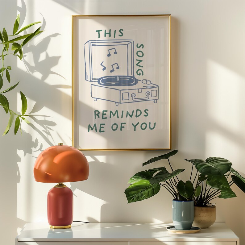 A minimalist illustration of a vintage record player with the text This song reminds me of you, placed on a neutral beige background. The design features a clean, hand-drawn aesthetic with simple, modern lines.