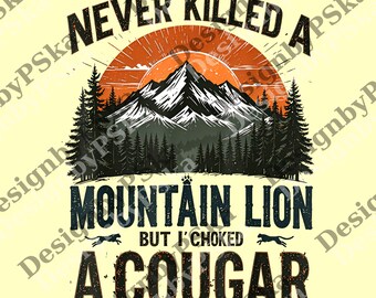 Peut inclure: Un design graphique avec le texte "NEVER KILLED A MOUNTAIN LION BUT I CHOKED A COUGAR" au-dessus d'une scène de montagne. Le design présente une chaîne de montagnes, des pins et un soleil levant en orange, noir et blanc.