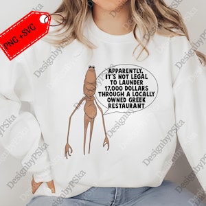 May include: White sweatshirt featuring a cartoon character with a speech bubble. The speech bubble reads: "Apparently, it's not legal to launder 17,000 dollars through a locally owned Greek restaurant."
