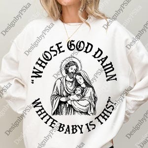 May include: White sweatshirt featuring a black graphic of a religious family with the text "WHOSE GOD DAMN WHITE BABY IS THIS?". The design is circular, with the family at the centre.