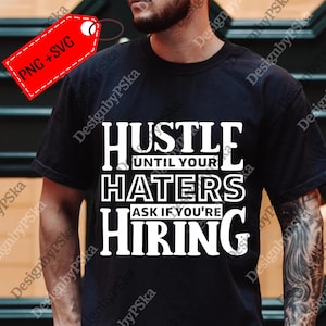 May include: Black t-shirt with the white text "HUSTLE UNTIL YOUR HATERS ASK IF YOU'RE HIRING." A red tag with "PNG + SVG" is attached to the shirt. The shirt is a casual wear item.