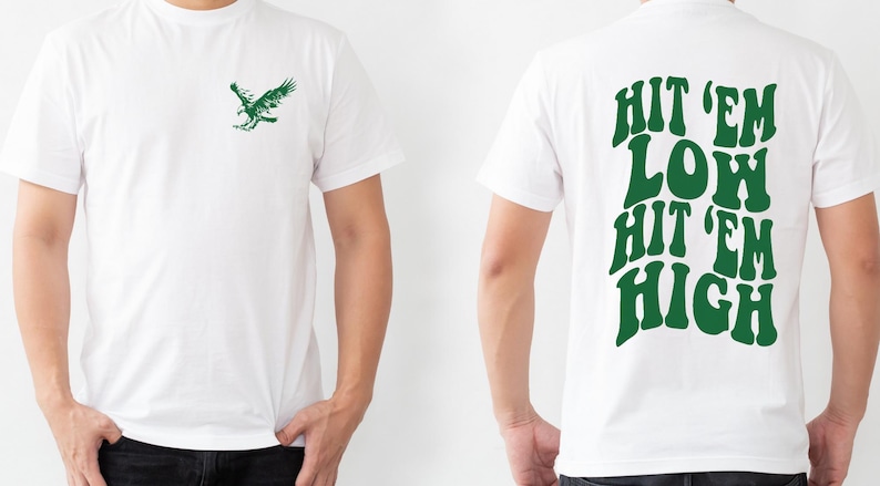 K&ouml;nnte beinhalten: Wei&szlig;es T-Shirt mit einem gr&uuml;nen Adler-Motiv auf der Vorderseite und dem Text "HIT 'EM LOW HIT 'EM HIGH" in Gr&uuml;n auf der R&uuml;ckseite.
