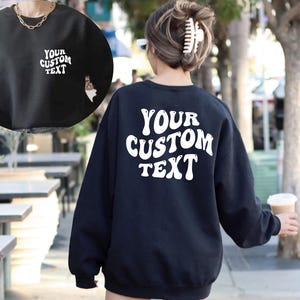 May include: Black sweatshirt with white text that says "YOUR CUSTOM TEXT" in a retro font.