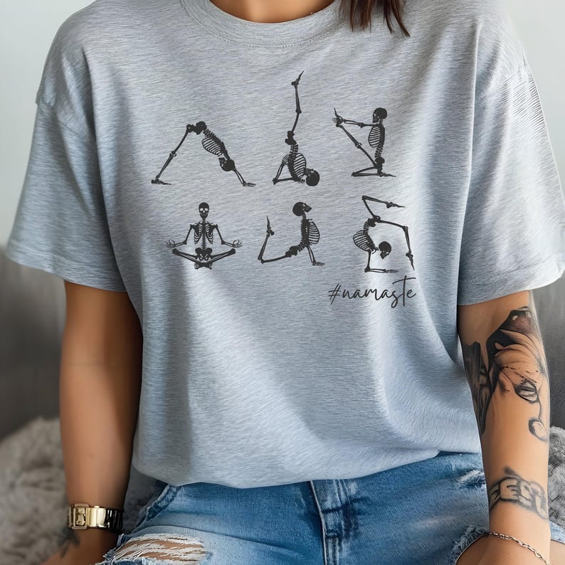 May include: A light gray t-shirt with a graphic of skeletons doing yoga poses. The text "#namaste" is printed below the skeletons.
