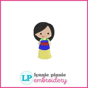 May include: Embroidered doll design with black hair, a tan face, and a colorful dress. The dress features blue, red, and yellow sections. The design is set against a white background with a pink border. The text "lynnie pinne embroidery" is at the bottom.