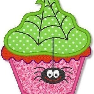 May include: A pink cupcake with green frosting and a spider web design. A black spider with googly eyes sits on top of the cupcake.