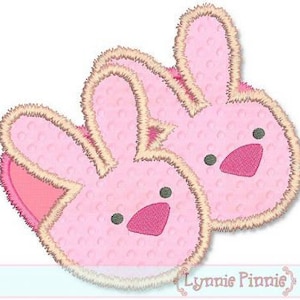 May include: Two pink bunny-shaped slippers with embroidered eyes, noses, and fluffy ears. The slippers have a light pink fuzzy texture.