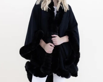 May include: Black cape with a faux fur trim. The cape is made of a soft, warm fabric and has a relaxed fit.