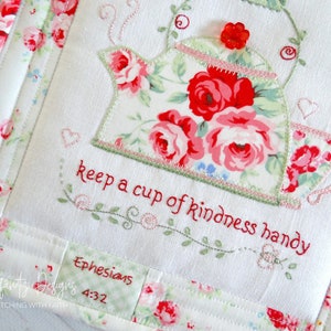 May include: White fabric with a red and green embroidered teapot and cup with the text "keep a cup of kindness handy" and "Ephesians 4:32".