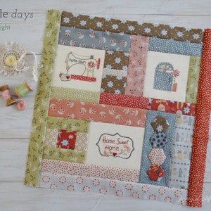 May include: A patchwork quilt block with a variety of fabrics in shades of red, green, blue, and brown. The block features a variety of designs, including a sewing machine, a mailbox, and a house with the text "Home Sweet Home".