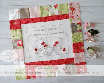 May include: A white fabric square with a red, green, and pink patchwork border. The center of the square features an embroidered quote: "The LORD is righteous in all His ways, and kind in all His works." The quote is surrounded by a small embroidered flower arrangement. The fabric square is on a white wooden surface with a spool of thread and a doily.