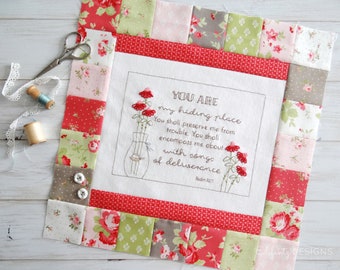 May include: A white fabric square with a floral border and a cross-stitch design that reads "YOU ARE my hiding place You shall preserve me from trouble. You shall encompass me about with songs of deliverance Psalm 32:7". The design includes a vase with flowers.