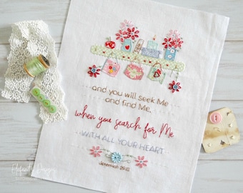 May include: Embroidered white fabric with a quote from Jeremiah 29:13, "And you will seek Me and find Me, when you search for Me with all your heart." The embroidery features a shelf with small jars, books, and flowers.