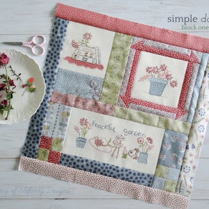 May include: A patchwork quilt block with a white background and a variety of floral patterns in shades of pink, green, blue, and red. The block features three embroidered scenes: a stack of books with flowers, a potted plant, and a peaceful garden scene. The block is titled "simple days, block one".
