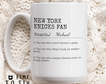May include: White ceramic mug with a black design that reads "New York Knicks Fan Noun(n.) Michael 1) The one who never misses a game. 2) The one who stays loud, no matter what. 3) The one who always cheers, even in tough times."