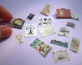 May include: A collection of miniature vintage-style ephemera, including illustrations of hot air balloons, ships, and an octopus. The pieces are in various shapes and sizes, with a muted color palette of beige, brown, and blue. The items are scattered on a light purple surface.
