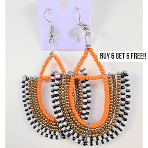 May include: A pair of beaded earrings with a silver hook. The earrings feature orange, gold, black, and white beads in a half-moon design. The text "BUY 6 GET 6 FREE!!" is visible.