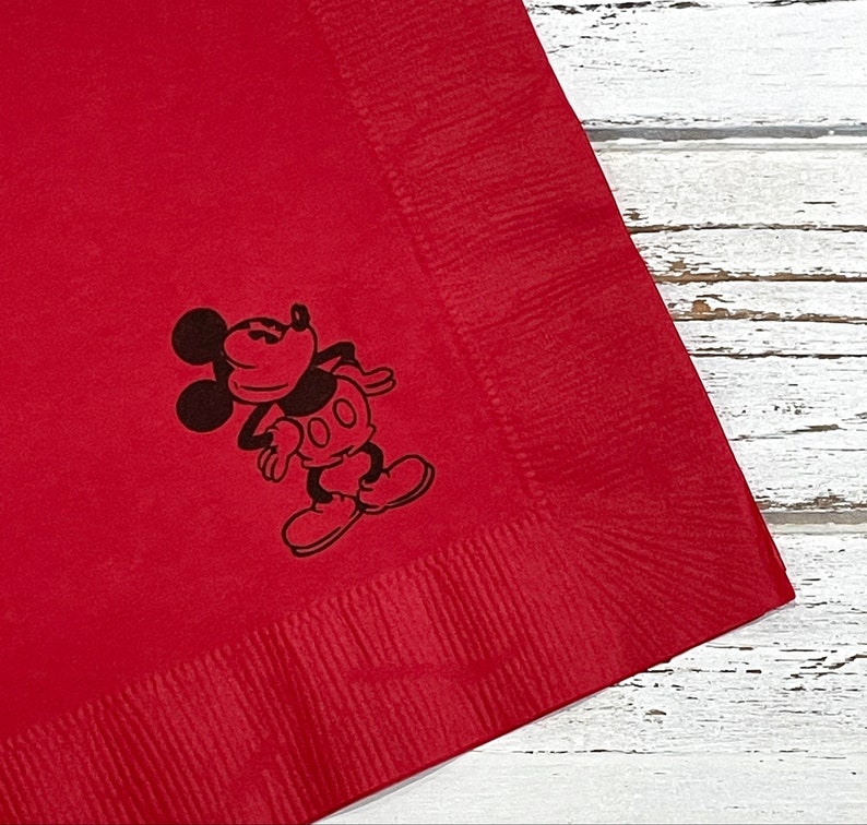 May include: Red paper napkin with a black and white image of Mickey Mouse in a classic pose.