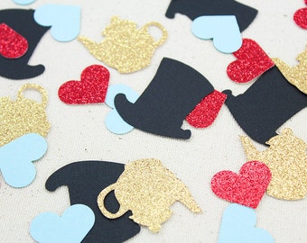 May include: A collection of confetti featuring various shapes and colors, including gold teapots, red hearts, blue hearts, and black top hats. The confetti is perfect for adding a whimsical touch to any party or celebration.