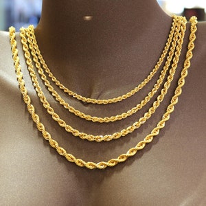 May include: Five gold rope chains of varying lengths and thicknesses displayed on a mannequin.