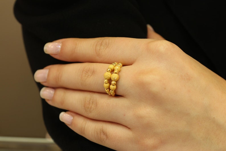 May include: A gold ring with a double row of textured beads.