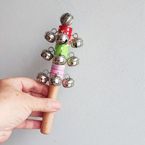 Vintage rattle toy, wooden rattle with metal bell chimes, wooden, multicoloured rattle instrument with bell chimes