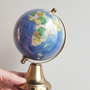 Blue world globe, decorative vintage globe on movable, rotating axis and brass base, colourful, elegant, world globe