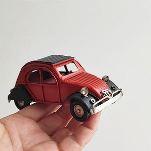 French car miniature, vintage citroen style retro collectible miniature with black fenders and  black roof, red citroen style car replica