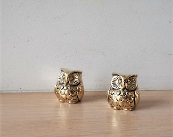 本の上に立つ真鍮製のフクロウの置物、緑のフェルト製の台座付き