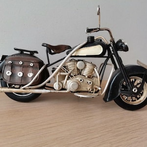 Black motorcycle miniature, retro style collectible miniature of black, vintage motorbike with brown saddlebags on sides, harley style bike