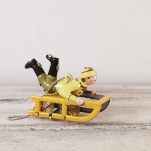 Adorno de árbol vintage de trineo amarillo con niño con ropa de invierno, trineo amarillo estilo juguete antiguo, miniatura coleccionable vintage, adorno de árbol