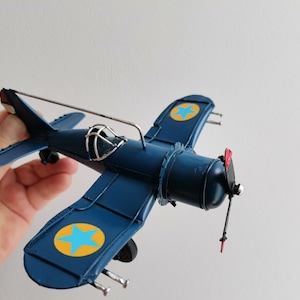 Blue metal plane, vintage, collectible miniature, retro plane with cockpit grid and moving propeller, royal blue airplane, retro aeroplane