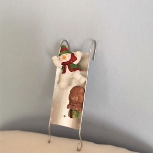Snowman ornament, christmas tree ornament of snowman on slad with sack of gifts, vintage metal and resin ornament