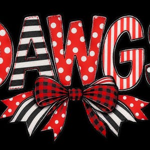 May include: The word DAWGS in a decorative font with red and white polka dots, black and white stripes, and red and white stripes. A large bow sits below the letters, featuring a red and black buffalo plaid pattern, black and white stripes, and red polka dots.