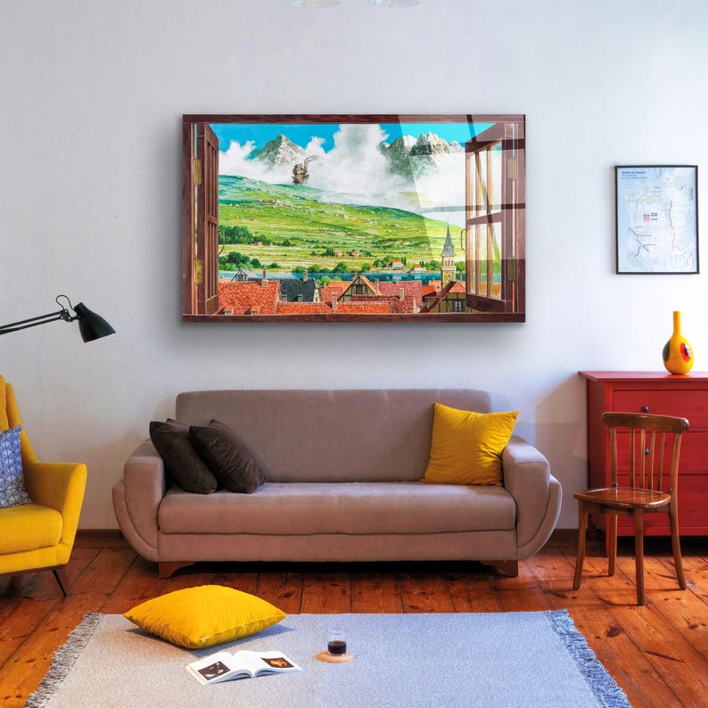 May include: A framed print of a window view with a picturesque landscape. The scene features a green valley with a small town in the distance, a blue sky with white clouds, and a brown wooden window frame.