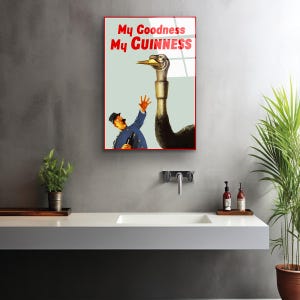 May include: A vintage poster advertising Guinness beer. The poster features a cartoon illustration of a man reaching out to a large ostrich with the text "My Goodness My GUINNESS" in red and white.