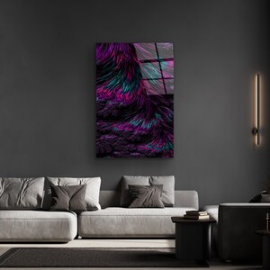 May include: Abstract wall art featuring a vibrant display of colors. The artwork showcases a blend of purple, teal, and pink hues, creating a dynamic and visually appealing composition. The piece is mounted on a dark gray wall, enhancing the artwork's vivid colors.