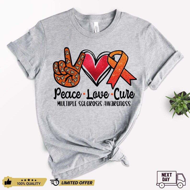 Puede incluir: Camiseta gris con un signo de paz, un coraz&oacute;n y una cinta naranja. El texto "Peace Love Cure" y "Multiple Sclerosis Awareness" est&aacute; impreso en la camiseta.